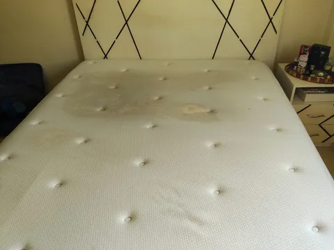 Matelas deux places avec auréoles jaunes, avant le nettoyage NADIFA